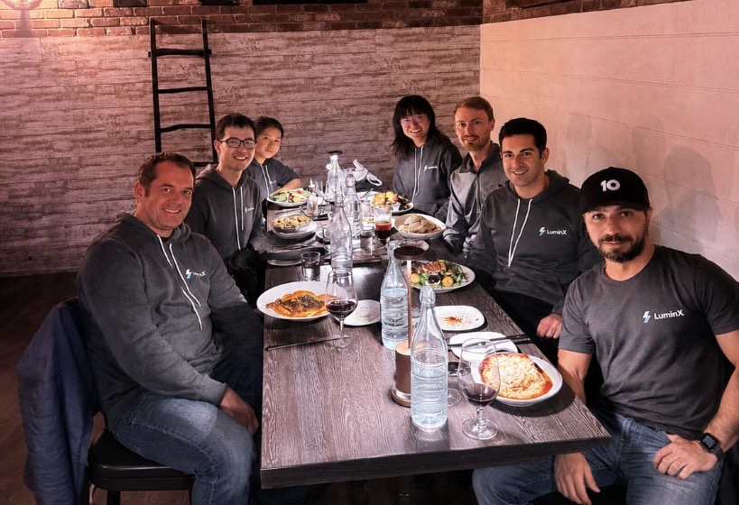 The LuminX team gathered around a table at dinner